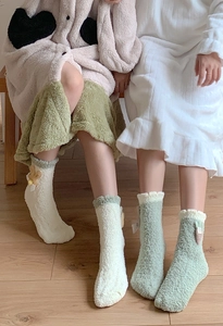Detail of soft coral fleece sleep socks with 3D floral accents in white and mint