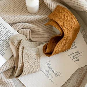 Close-up of vintage diamond-patterned wool socks in beige and mustard yellow