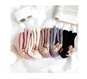 Detail of five pairs of thick coral fleece winter socks with cute cat paw color-block design