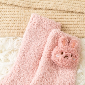 Close-up of pink coral fleece socks featuring a 3D plush rabbit and soft thermal texture