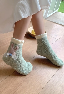 Detail of green coral fleece home socks with cute rabbit patch and lace bow decoration
