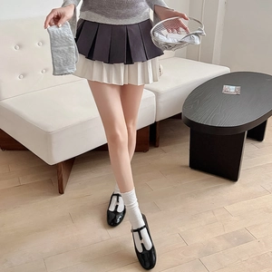Detail shot of a dark pleated double-layer skirt paired with white lace socks and shoes