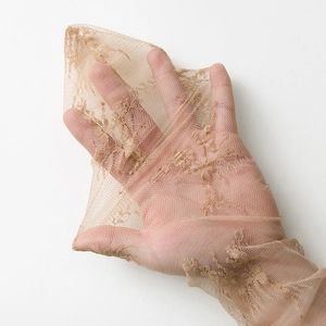 Detail shot of the breathable sheer lace mesh fabric with exquisite embroidery textures