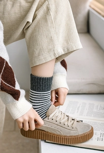 Détail de chaussettes thermiques épaisses en coton à rayures gris et blanc avec chaussures