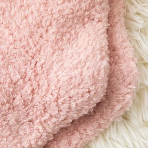 Close-up of pink coral fleece fabric texture showing soft fuzzy warm teddy velvet material