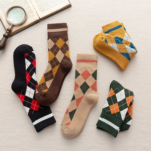 Gros plan de cinq paires de chaussettes à motifs de losanges sur un fond en lin rustique