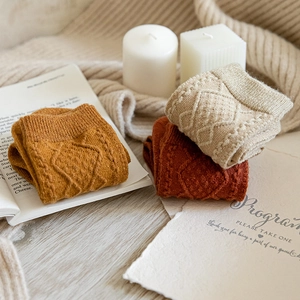 Detailed knit texture of wool socks in mustard yellow, brick red and beige colors