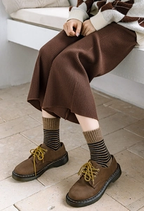 Gros plan de chaussures en cuir marron et pantalon en maille rayée de style rétro