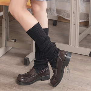 Japanese style black chunky knit leg warmers paired with retro loafers in classroom