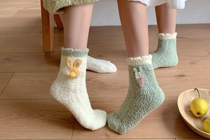 Detailed view of thick coral fleece socks with cute bunny ears and carrot decorations