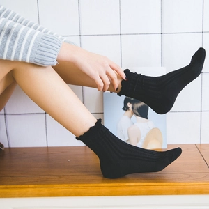 Classic black ribbed calf socks featuring elegant ruffled cuffs and soft cotton blend fabric