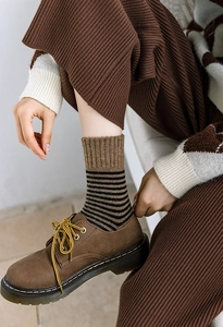 Gros plan de chaussettes à rayures rétro portées avec des chaussures en cuir marron
