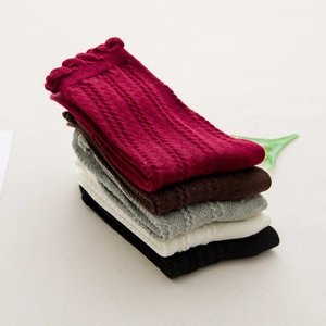 Five pairs of solid color cotton crew socks with frill cuffs and cable knit texture