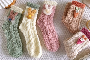 Detail of five pairs colorful thick coral fleece socks with cute 3D rabbit and carrot motifs