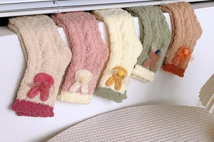 Detailed view of thick coral fleece sleep socks with 3D bunny ears and floral accents