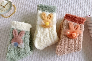 Close-up of thick coral fleece winter socks with cute 3D bunny head and mesh bow details