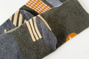 Macro detail of patchwork knit tabi socks with houndstooth and geometric patterns