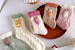 Detail of coral fleece winter socks featuring 3D rabbit and carrot decorations
