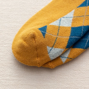 Vue détaillée du motif losanges et couture lisse des chaussettes d'hiver jaunes