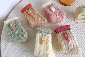 Detailed view of plush coral fleece socks with cute rabbit and carrot 3D appliques