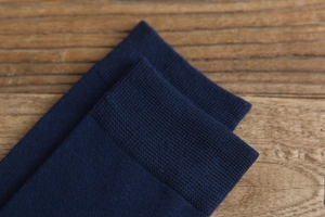 Close-up of fine ribbed cuff and knit texture on dark blue high cotton socks