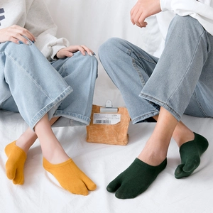 Detail view of cotton two-toe tabi boat socks in ginger yellow and dark green colors