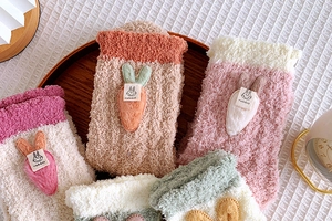 Detail showing plush coral fleece texture and cute 3D carrot rabbit embellishments