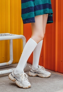 Primer plano de zapatillas beige con plataforma y calcetines altos de algodón blanco