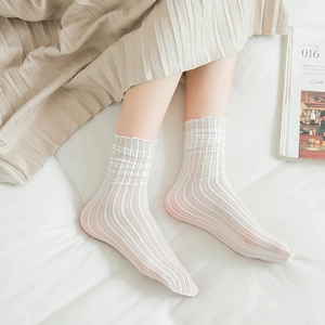 Close-up of white vertical striped mesh socks with elegant lettuce trim in a lifestyle setting