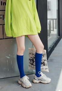Estilo urbano de calcetines altos azul real con zapatillas retro en color beige