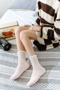 Dettaglio di calze in pile corallo rosa con risvolto in peluche bianco per donna