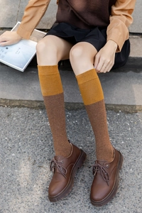 Détail de chaussettes montantes vintage bicolores gingembre et marron avec des chaussures