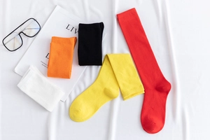 Plano detalle de calcetines de algodón de colores en rojo, amarillo, negro, naranja y blanco