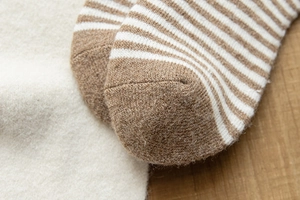 Gros plan de chaussettes thermiques rayées marron et blanc montrant la maille dense