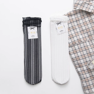 Detailed view of striped and white ruffled socks with mesh texture on white background