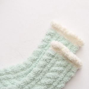 Dettaglio di calze invernali in pile corallo verde menta con spessa fodera in peluche bianco