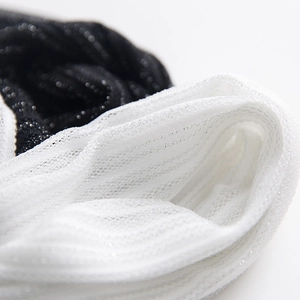Detailed macro view of sheer mesh fabric with sparkling metallic silver glitter thread