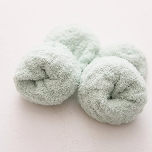 Dettaglio ravvicinato di calze in pile corallo verde menta con morbida texture ciniglia