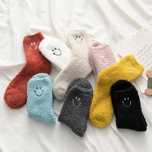 Detailed view of eight assorted colors of coral fleece socks featuring embroidered smile faces