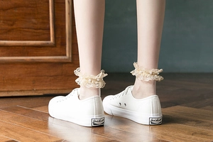 Gros plan de chaussettes lolita beige avec bordure en dentelle et perles délicates