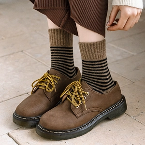 Chaussures derby brunes avec couture jaune et chaussettes rayées en tissu éponge d'hiver