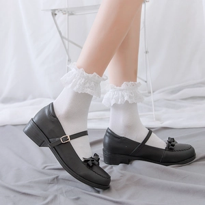 Detailed side view of white mesh lolita socks with lace trim paired with black Mary Jane shoes