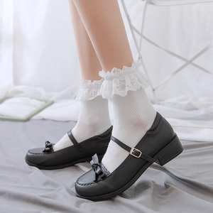 Close-up of black Mary Jane shoes with leather bow and white lace ruffle Lolita socks