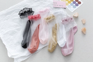 Détail de chaussettes en dentelle transparente avec perles en plusieurs couleurs