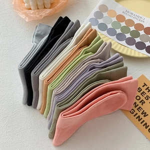 Close-up of neatly folded Morandi color cotton socks in soft pink, green, and beige