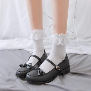 Detailed close-up of white mesh lace socks paired with black Mary Jane bow shoes