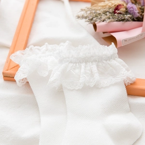 Detailed view of white cotton socks with elegant double-layer ruffled lace edge finish