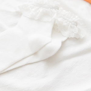 Close-up of white Lolita style lace ruffled edge on cotton mesh princess socks