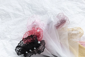Détail de chaussettes en dentelle transparente avec perles et bords à volants fins