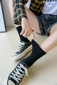 Close-up of black ribbed two-toe socks showing high elasticity and soft cotton texture